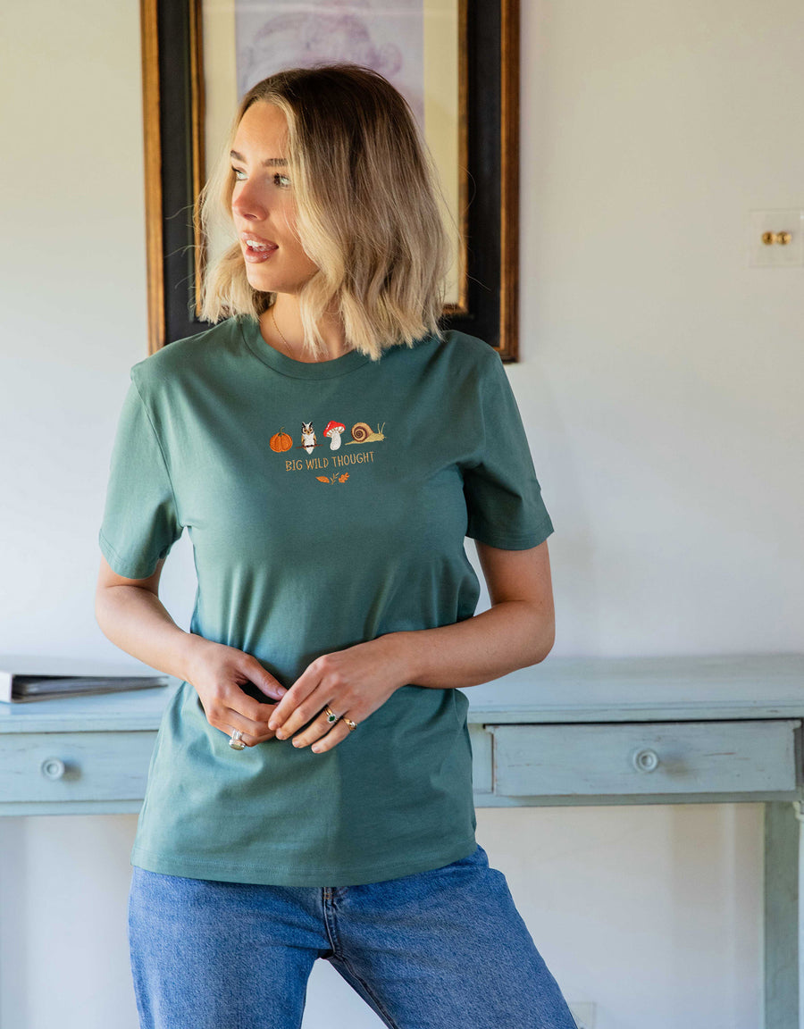 Cosy Autumn embroidered unisex t-shirt in Dusky Green worn by a model, with a pumpkin, owl, toadstool and snail design