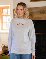 Cosy Autumn embroidered unisex sweatshirt in Light Grey Heather worn by a model, with a pumpkin, owl, toadstool and snail design