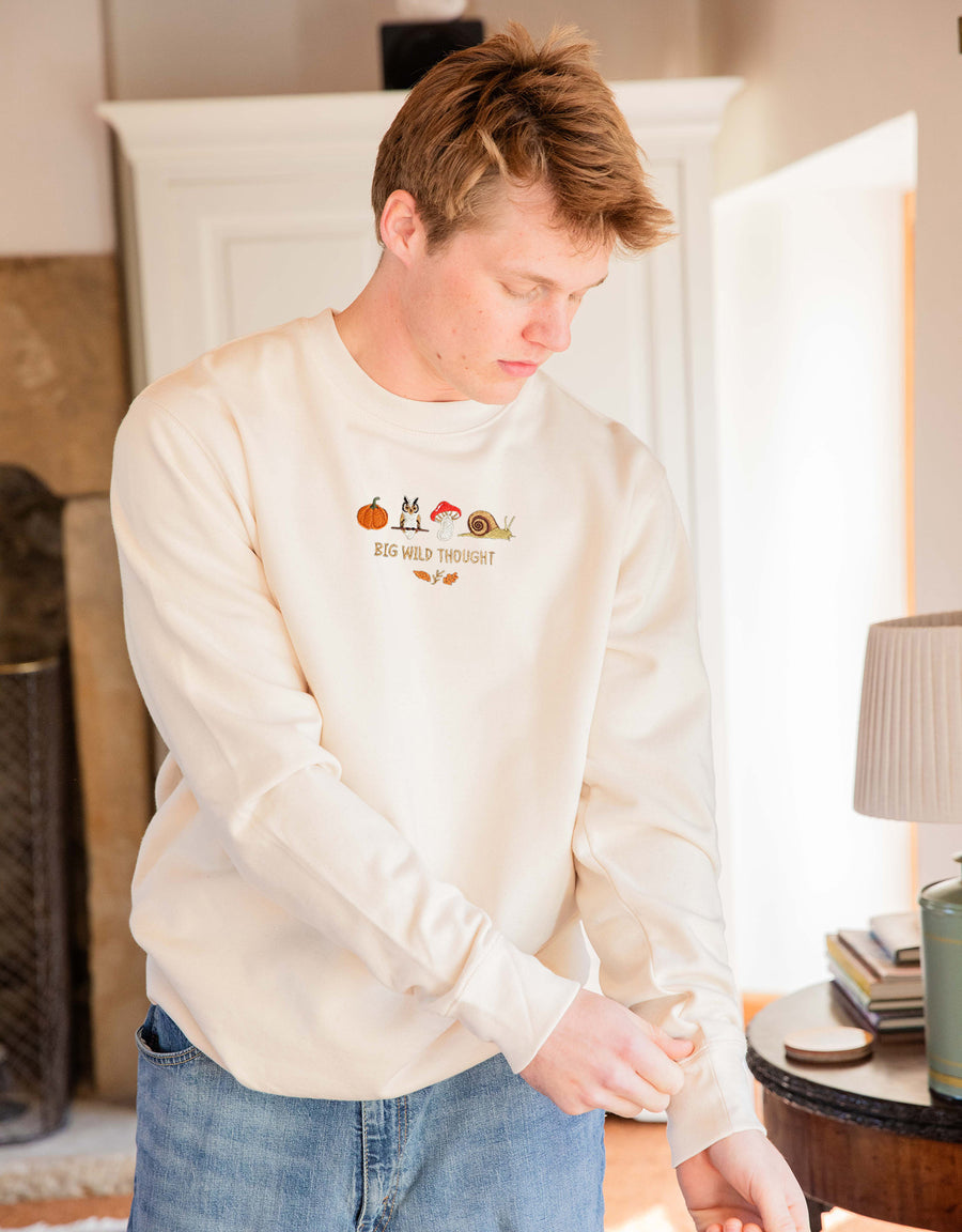 Cosy Autumn embroidered unisex sweatshirt in Natural worn by a model, with a pumpkin, owl, toadstool and snail design