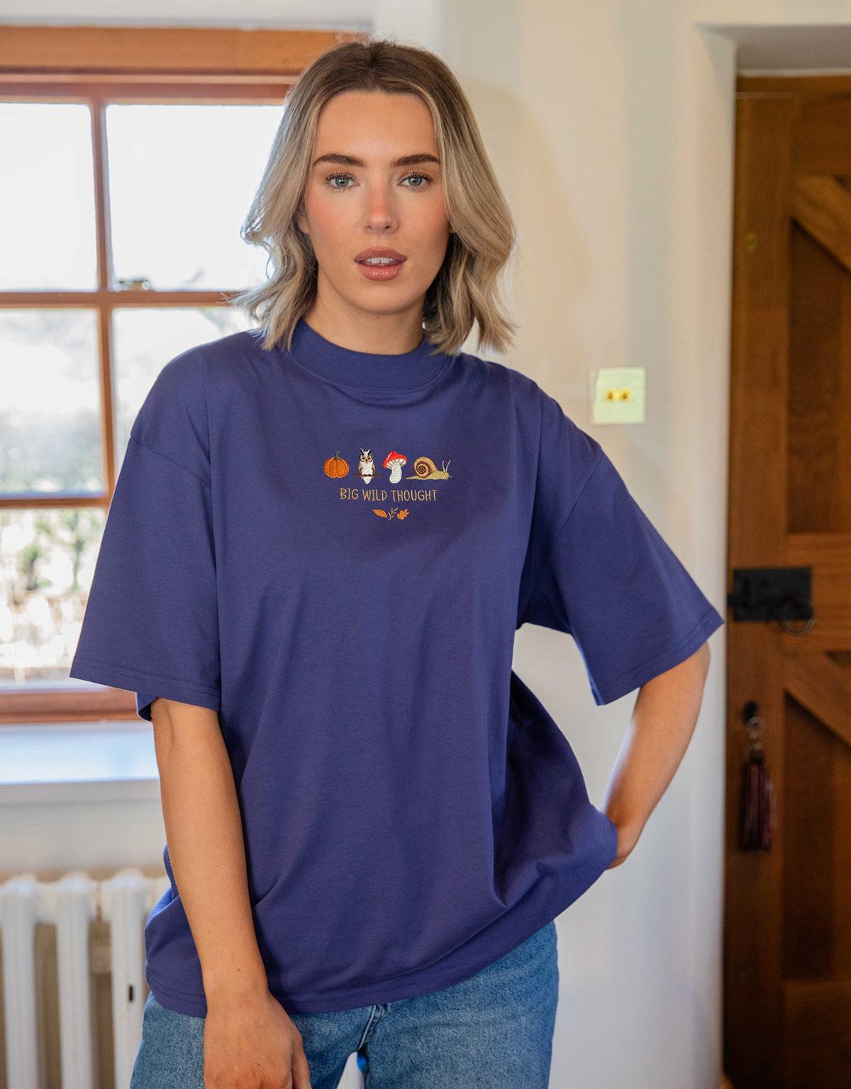 Cosy Autumn embroidered unisex oversized tee in Deep Blue worn by a model, with a pumpkin, owl, toadstool and snail design