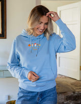 Cosy Autumn embroidered unisex hoodie in Pastel Blue worn by a model, with a pumpkin, owl, toadstool and snail design