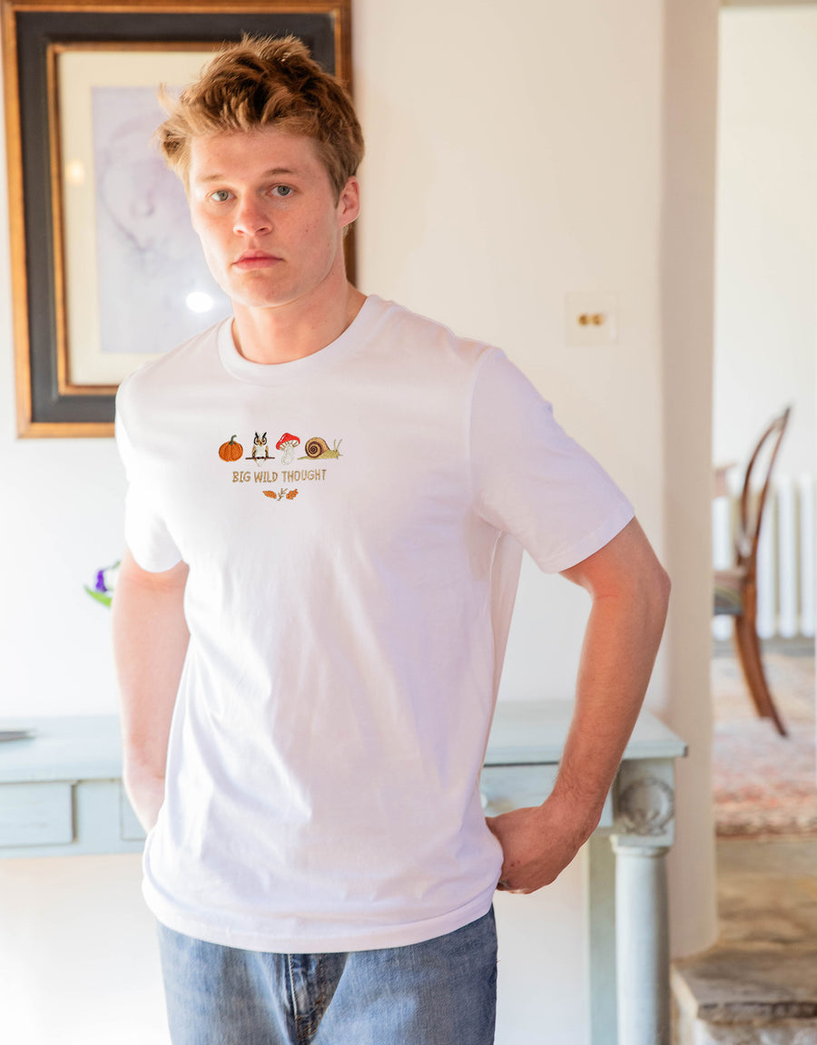 Cosy Autumn embroidered unisex t-shirt in White worn by a model, with a pumpkin, owl, toadstool and snail design
